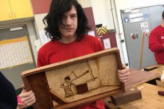 Einer unserer Lehrlinge aus der Tischlerei hält sein selbstgemachtes Werkstück in die Kamera © wienwork Einer unserer Lehrlinge aus der Tischlerei hält sein selbstgemachtes Werkstück in die Kamera © wienwork