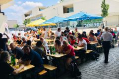 MitarbeiterInnen, Lehrlinge und weiter Gäste sitzen auf der Sonnenterrasse vor dem Speiseamt zusammen und unterhalten sich © wienwork MitarbeiterInnen, Lehrlinge und weiter Gäste sitzen auf der Sonnenterrasse vor dem Speiseamt zusammen und unterhalten sich © wienwork