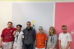 Lehrlinge aus der Malerei gemeinsam mit Ausbildner vor Logo der AIDS Hilfe © Wien Work Lehrlinge aus der Malerei gemeinsam mit Ausbildner vor Logo der AIDS Hilfe © Wien Work