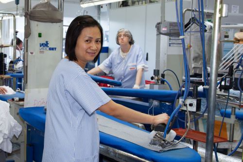Mitarbeiterin aus der Textilreinigung bei der Handbügelstation © Wien Work